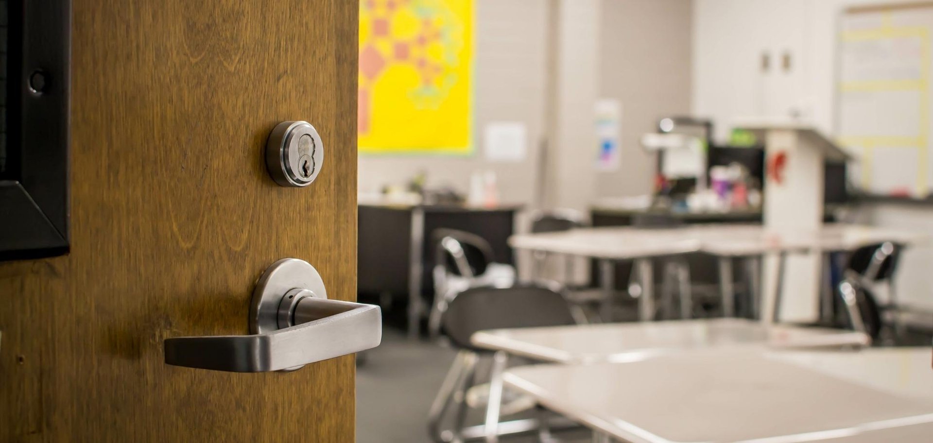 Education Facilities 2 AustClean classroom cleaning service – open wooden classroom door revealing clean desks, chairs, and colourful murals after professional education facility cleaning in Australia.