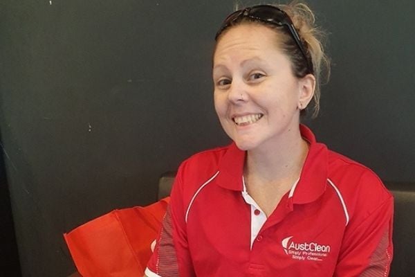 Springfield Lakes Interior Cleaning 13 AustClean Springfield Lakes cleaning specialist – smiling woman in red AustClean polo shirt indoors with sunglasses on head and red bag, providing expert interior and carpet cleaning services for Springfield Lakes region.