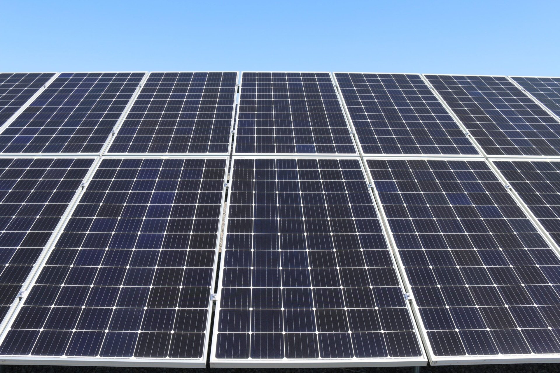 Keeping your roof and solar panels clean 1 Professional solar panel cleaning services - AustClean roof and solar panel maintenance team cleaning blue solar panels on Australian residential roof under clear blue sky for optimal energy efficiency